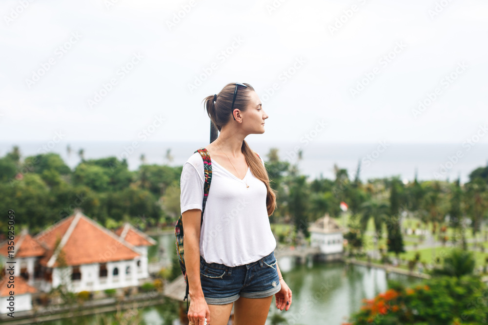 Girl tourist in the park with Palace on Water