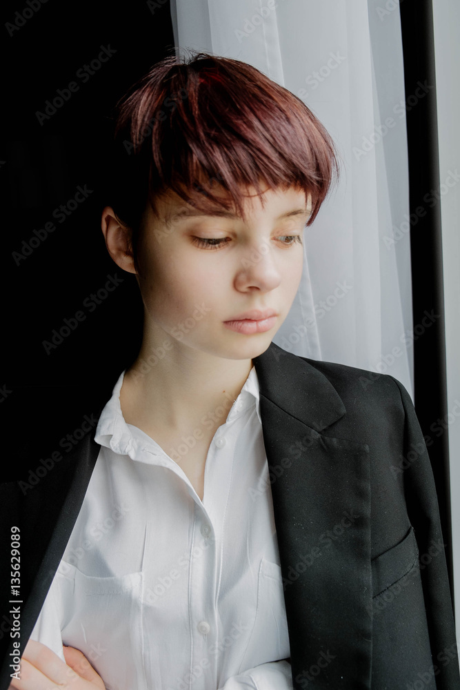 portrait of a beautiful young girl with short hair near the window in a jacket, fashion portrait of a beautiful young girl with short hair near the window in a jacket, fashion