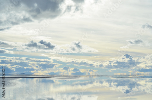 Céu de nuvens ao entardecer no salar de Uyuni espelhado por água photo