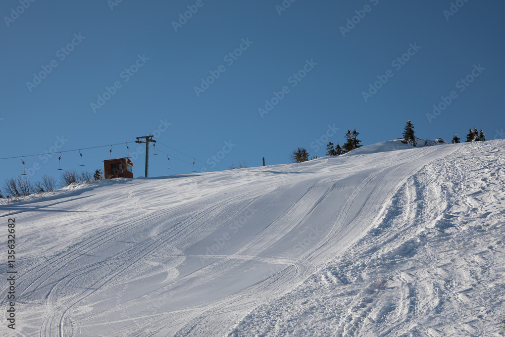 view of snow covered ski slope in the mountains. On the side are installed safety nets. view of snow covered ski slope in the mountains. On the side are installed safety nets.