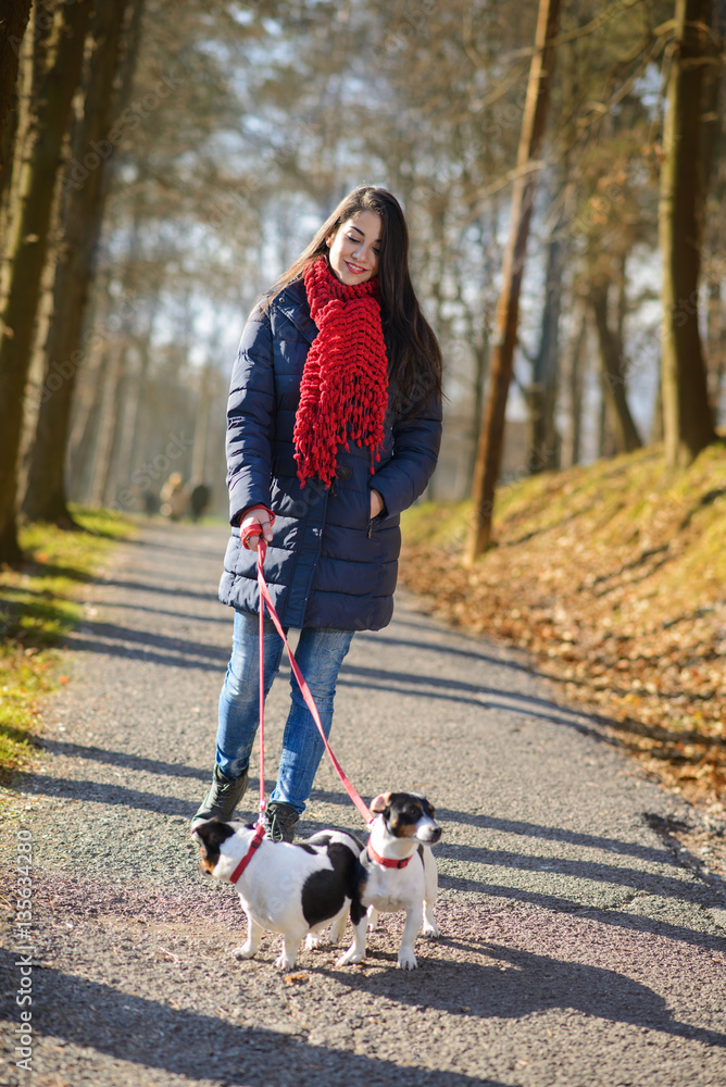 People and dogs outdoors. Beautiful and happy woman enjoying in autumn park walking with her Jack Russell terrier..Colored photo People and dogs outdoors. Beautiful and happy woman enjoying in autumn park walking with her Jack Russell terrier..Colored photo