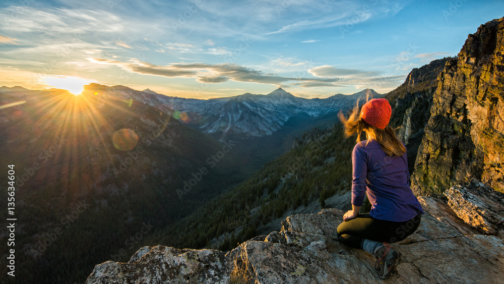 Fototapeta premium A hiker watches sunset over the Bitteroots from Bear Creek Overlook in the Selway-Bitterroot Wilderness.