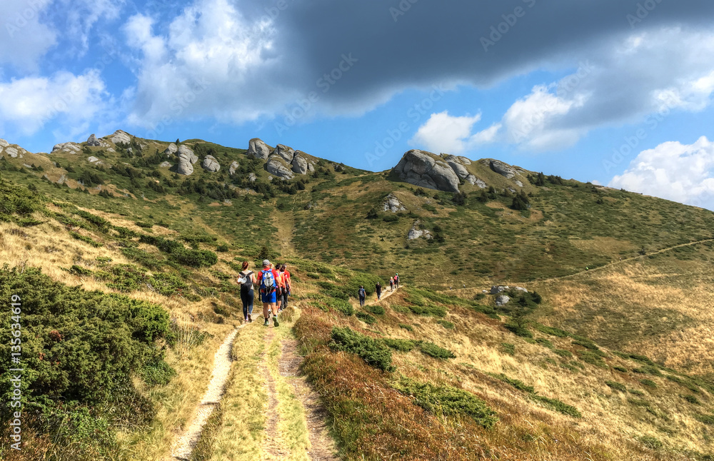 Tourists walking the path on Ciucas top ridge  mountain, in summer season, Romania