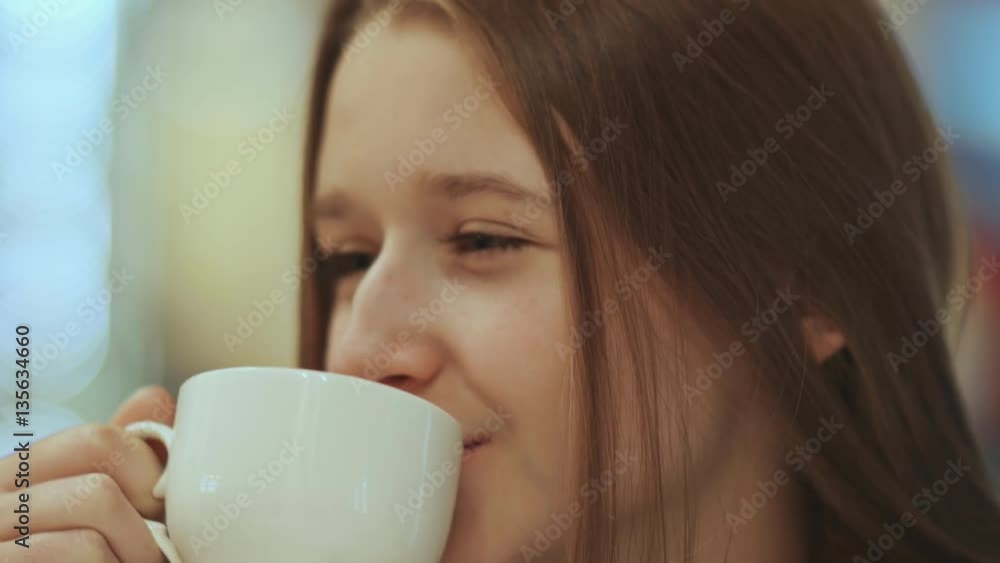 Close-up face of young beautiful schoolgirl, drinking coffee from a cup. Close-up face of young beautiful schoolgirl, drinking coffee from a cup.