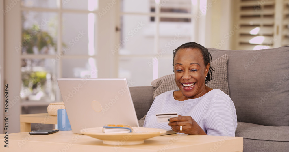 An older black woman pays her bills on her laptop An older black woman pays her bills on her laptop