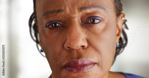 A close-up of a elderly black woman looking sad photo