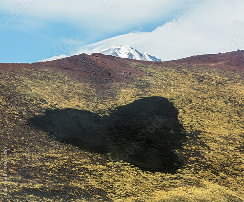 Natural formation in the form of heart on the hillside with volcano Ostry Tolbachik on background- Kamchatka, Russia photo