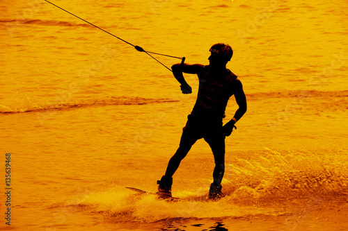 Silhouette man is playing water sport.