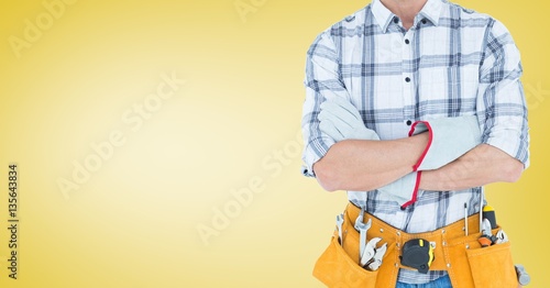 Mid section of handy man standing with arms crossed