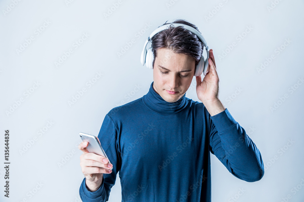 young man wearing wireless headphone and listening to music with smart phone
