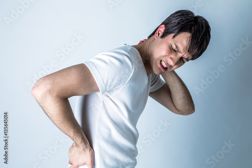 young man having a pain in his neck and low back
