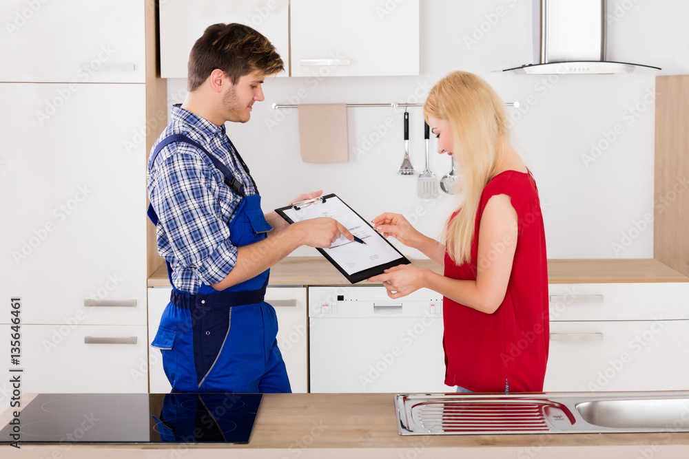 Fototapeta premium Male Plumber Showing Woman To Sign The Invoice