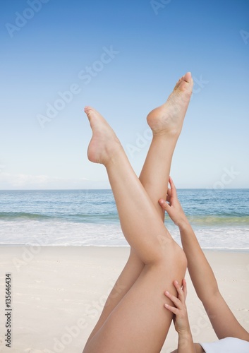 Woman touching her legs on the beach