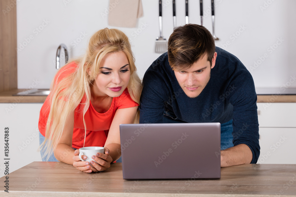 Couple Using Laptop At Home Couple Using Laptop At Home