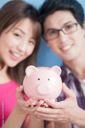  couple hold pink piggy bank