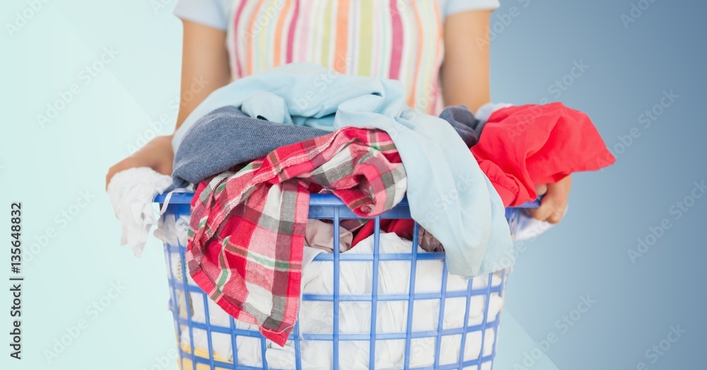 Mid section of female cleaner holding laundry Mid section of female cleaner holding laundry