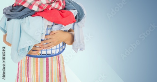 Mid section of woman holding basket full of clothes