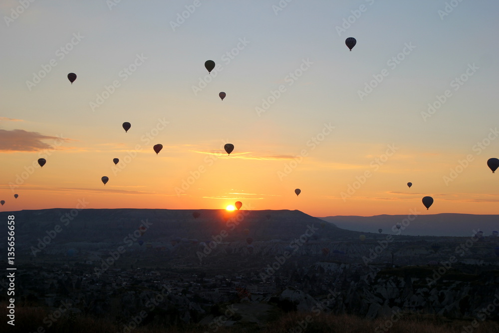 Travel to Goreme, Cappadocia, Turkey. The sunrise in the mountains with a lot of air hot balloons in the sky.