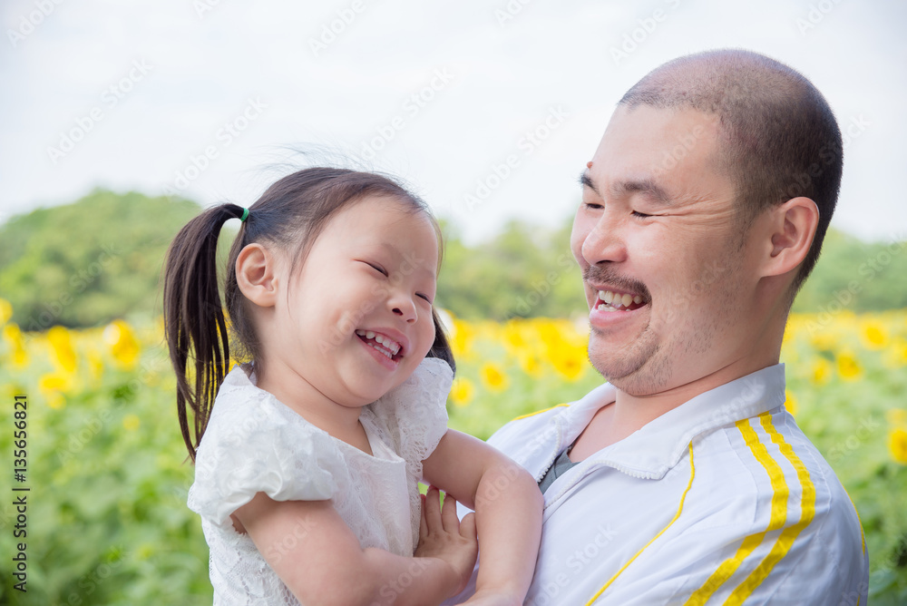 Obraz premium Asian father and his daughter smiling in park