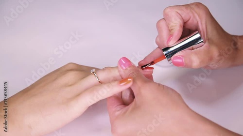 Wallpaper Mural Woman manicurist hand putting bright orange polish on nails in beauty saloon, close up Torontodigital.ca