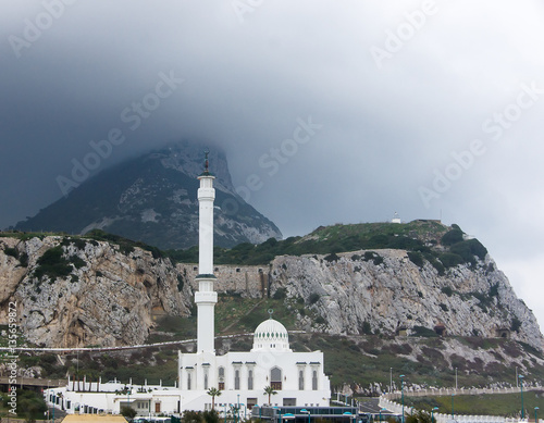 View of the white mosque against the background of rocks covered with clouds. Also known as the King Fahd bin Abdulaziz al-Saud Mosque or the Mosque of the Custodian of the Two Holy Mosques photo