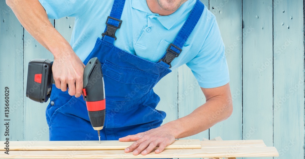 Handyman drilling wooden plank with drilling machine Handyman drilling wooden plank with drilling machine
