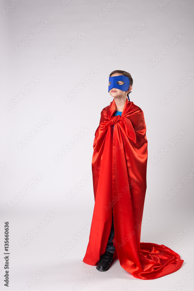 Playful superman kid posing in studio Playful superman kid posing in studio