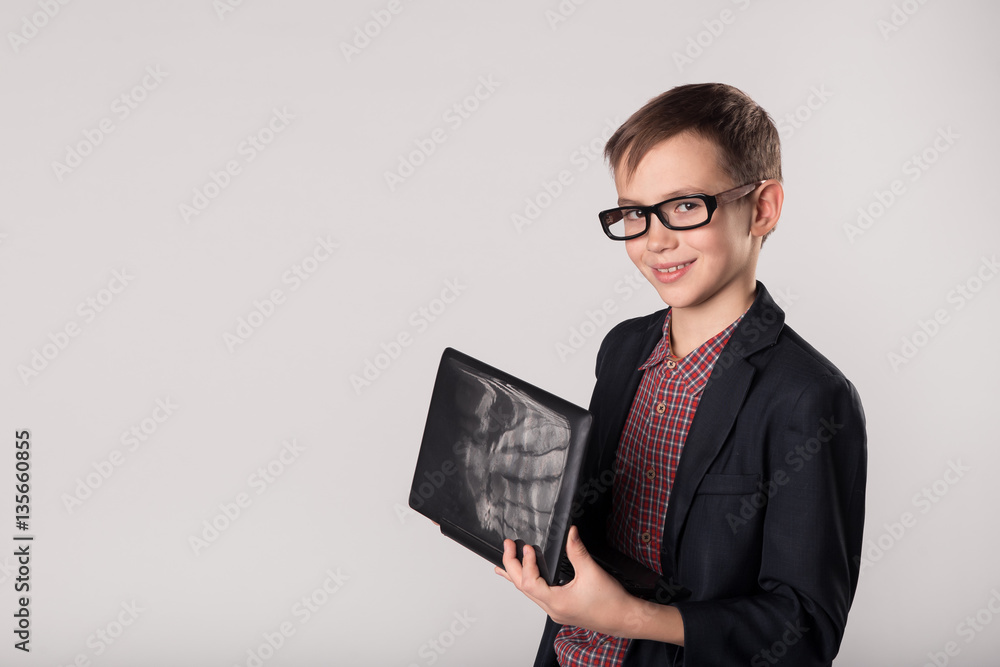 Young business boy holding laptop in his hands Young business boy holding laptop in his hands