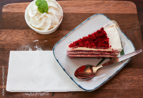 Red velvet cake and whipping cream on table 