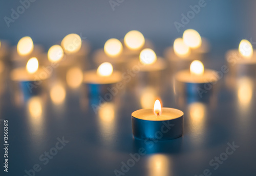 Flame of many candles burning on the background blue color