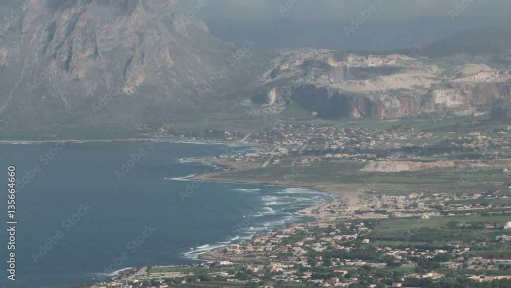 Long shot of a windswept Sicilian coastline from Mount Erice. The village of Cornino and Monte Cofano are in the background Long shot of a windswept Sicilian coastline from Mount Erice. The village of Cornino and Monte Cofano are in the background