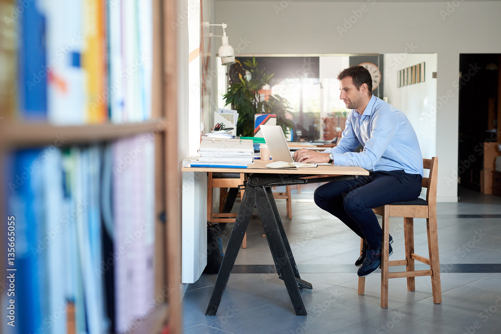 Businessman hard at work on a laptop in an office
