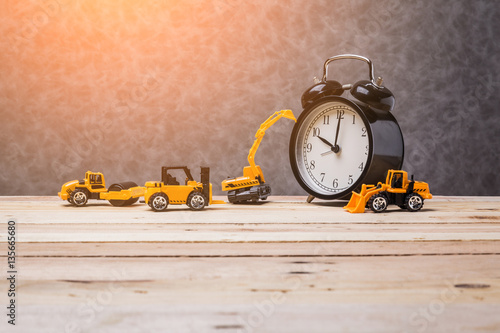 Obraz na płótnie vintage black alarmclock with toy car business construction idea