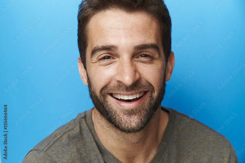 Obraz premium Happy chap in blue studio, portrait