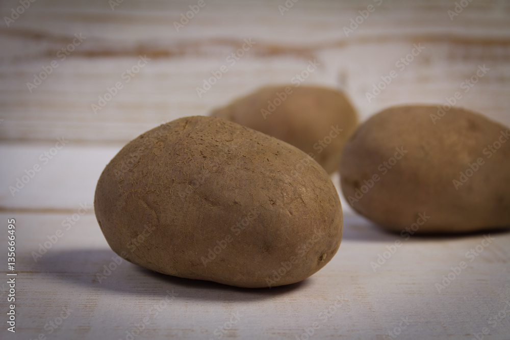 Fototapeta premium Potatoes on wooden background