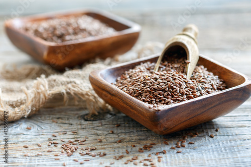 Flax seeds in a square wooden bowl.