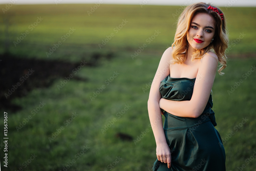 Yong elegance blonde girl at green dress on the garden in spring Yong elegance blonde girl at green dress on the garden in spring