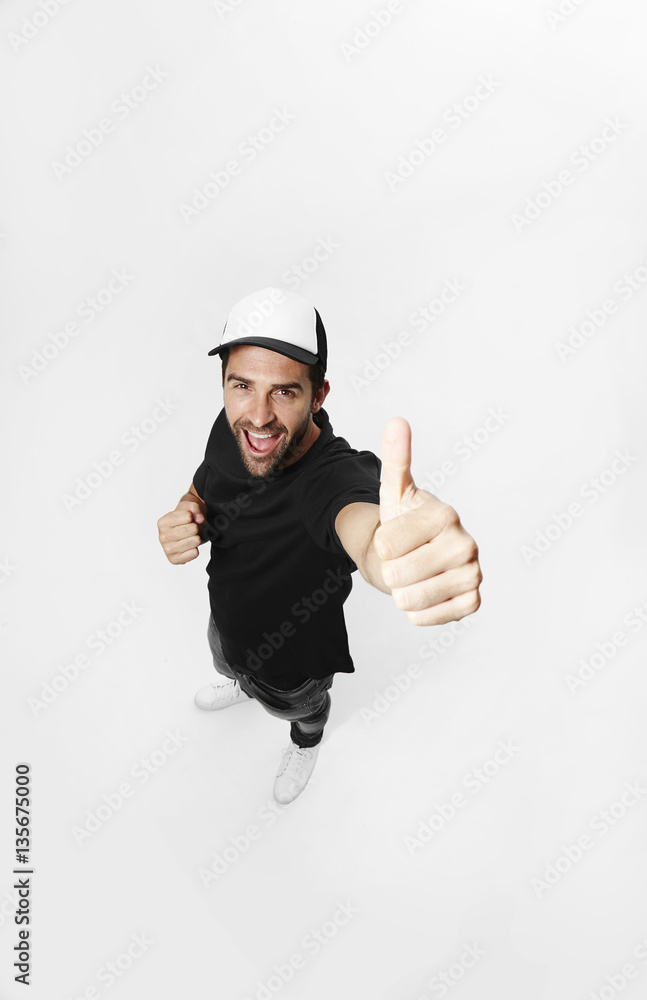 Dude in cap giving thumbs up to camera Dude in cap giving thumbs up to camera