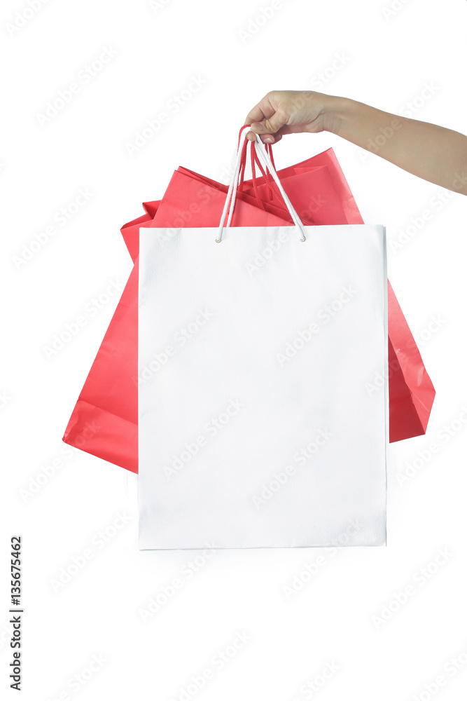Hand with paper bags on the white background - studio shoot, shopping and consumerism concept
