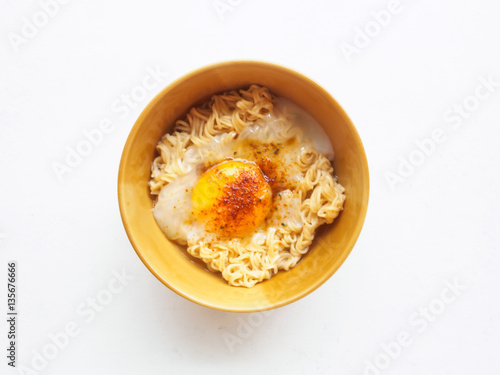 Top view bowl of instant noodle and soft egg boiled on white bac