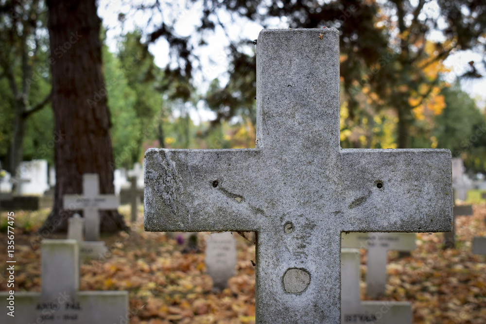 Old, signless christian tombstone at a cemetery in autumn