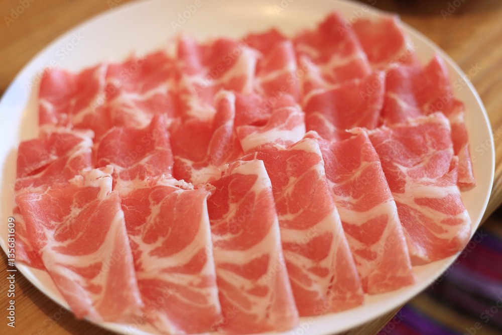 Raw pork sliced in white dish for shabushabu, Japanese recipe.