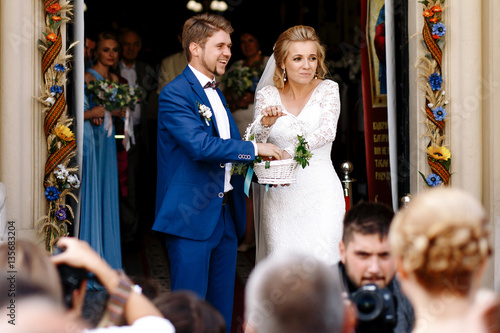 Wedding couple takes sweets from white bascket to throw them int