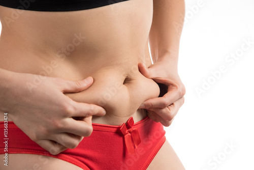 The girl in a red underwear to touch the fat on your stomach and Stock  Photo