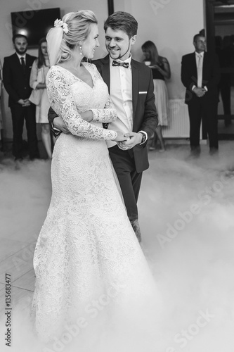 Groom holds bride's hand tender during their first dance