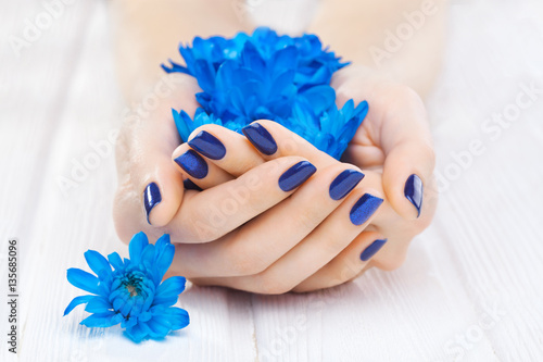 blue manicure with chrysanthemum flowers.
