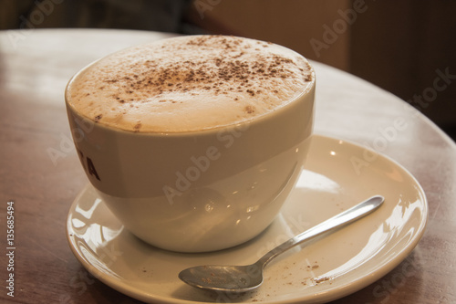 Чашка капучино в кафе с корицей photo