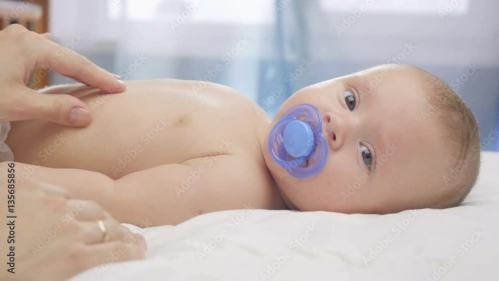 Happy baby. Mom stroking newborn baby. Happy baby. Mom stroking newborn baby.