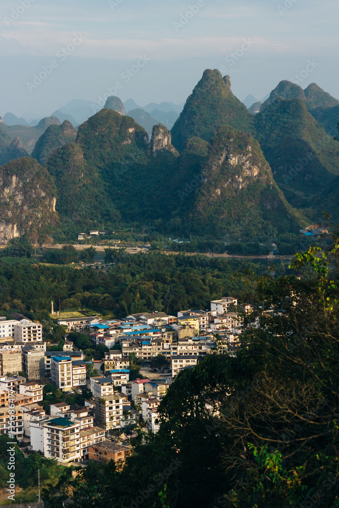 The view of the cityscape and karst rock mountains in Yangshuo, Guilin region, Guangxi Province, China.