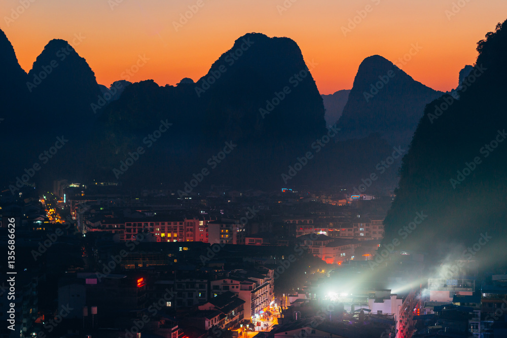 Obraz Evening colorful view of the cityscape and karst rock mountains in Yangshuo, Guilin region, Guangxi Province, China.